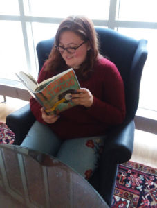 portrait of Cam Kelley reading the book MaddAddam by Margaret Atwood